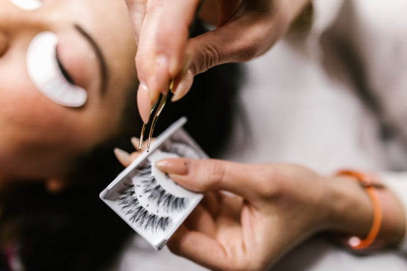 Comparaison faux cils et extensions, pose avec pince en salon beauté.