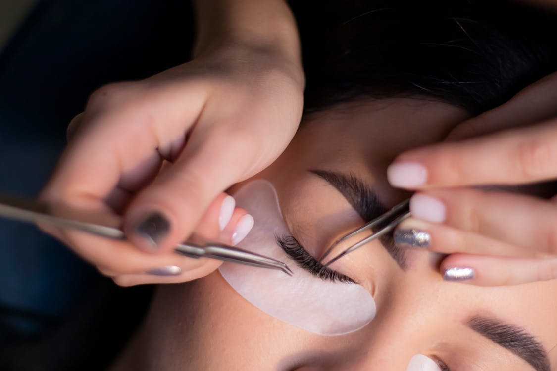 Technicienne appliquant un rehaussement de cils, résultat naturel et bouclé.